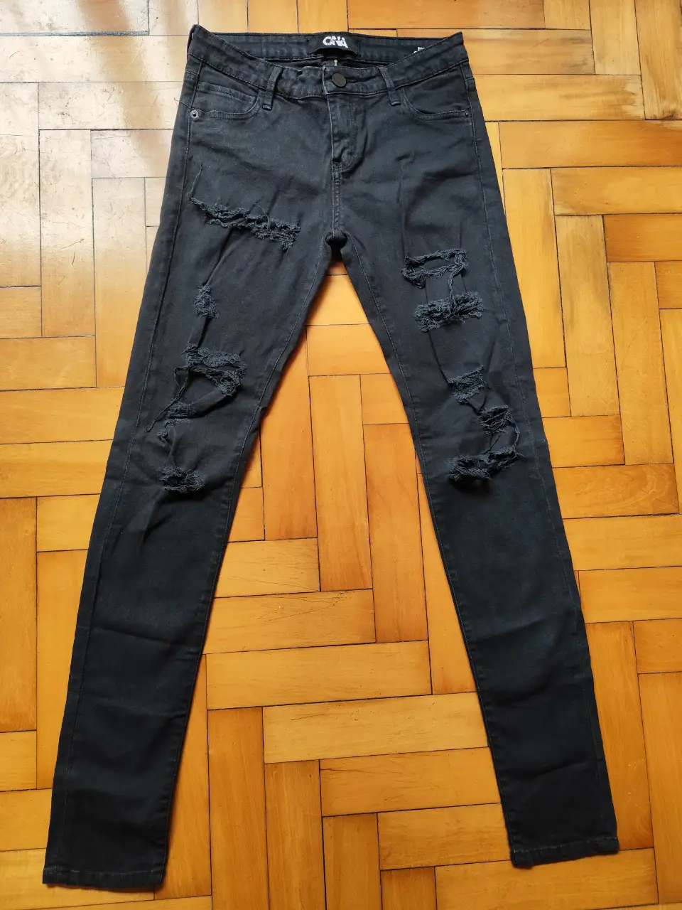 Jeans negros de mujer con roturas, tiro medio y corte skinny. Marca ONA SAEZ