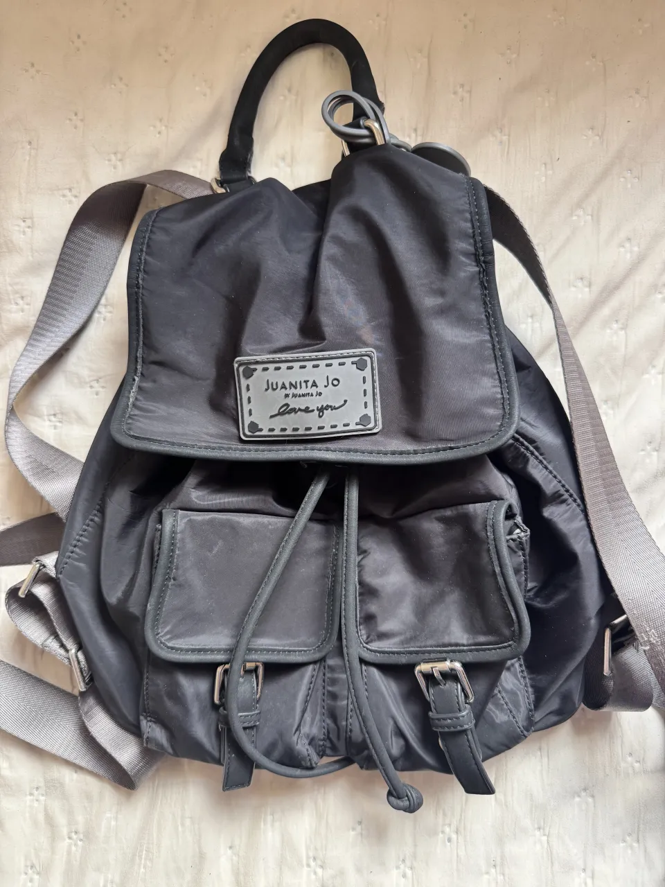 Mochila negra de Juanita Jo, ideal para el día a día o para llevar tus esenciales a todos lados. Con múltiples bolsillos y un diseño práctico.