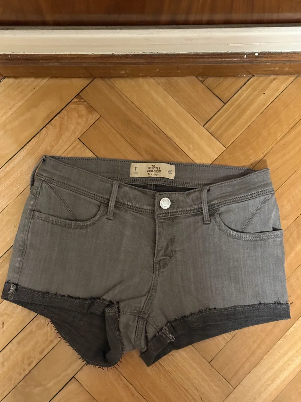 mini shorts de jean grises con roturas y detalles deshilachados en los bordes.
