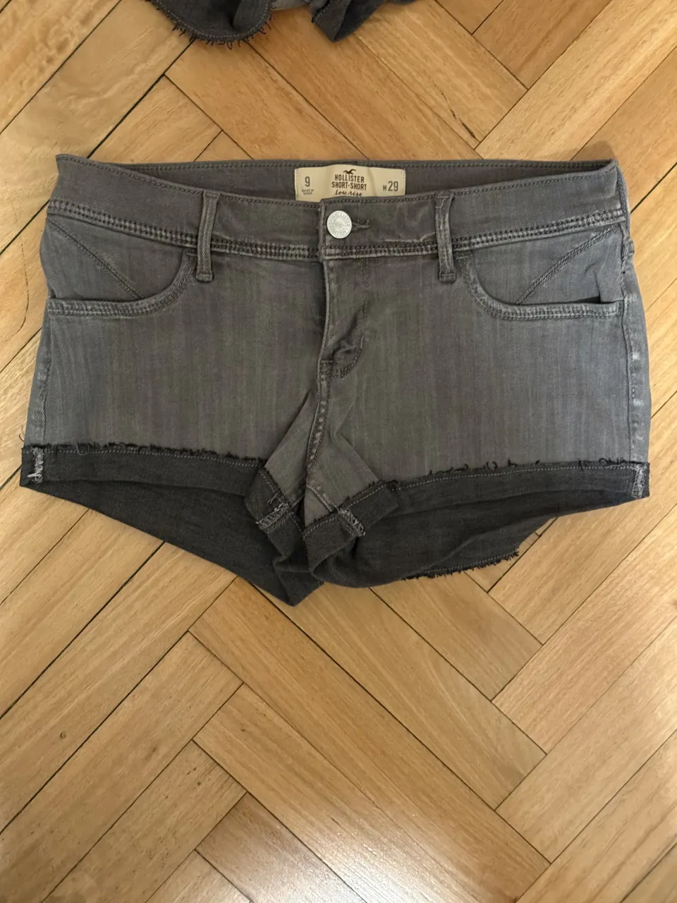 mini shorts de jean grises con roturas y dobladillo deshilachado en los bordes.