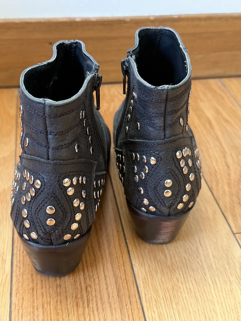 Botines negros de cuero con tachas plateadas. Diseño con cierre lateral y detalles en relieve. Ideales para un look rockero y canchero.
