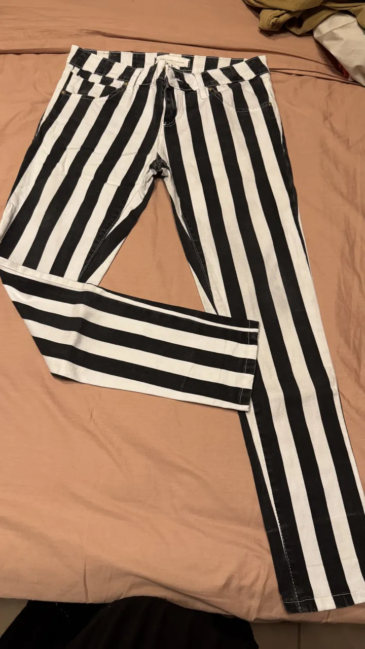 Pantalón de jean a rayas verticales blancas y negras.