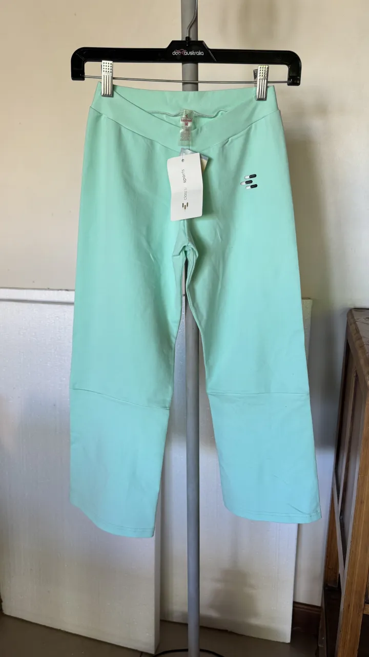 Pantalón deportivo color verde menta con aberturas en los tobillos. Posee un pequeño logo bordado en la parte superior izquierda.