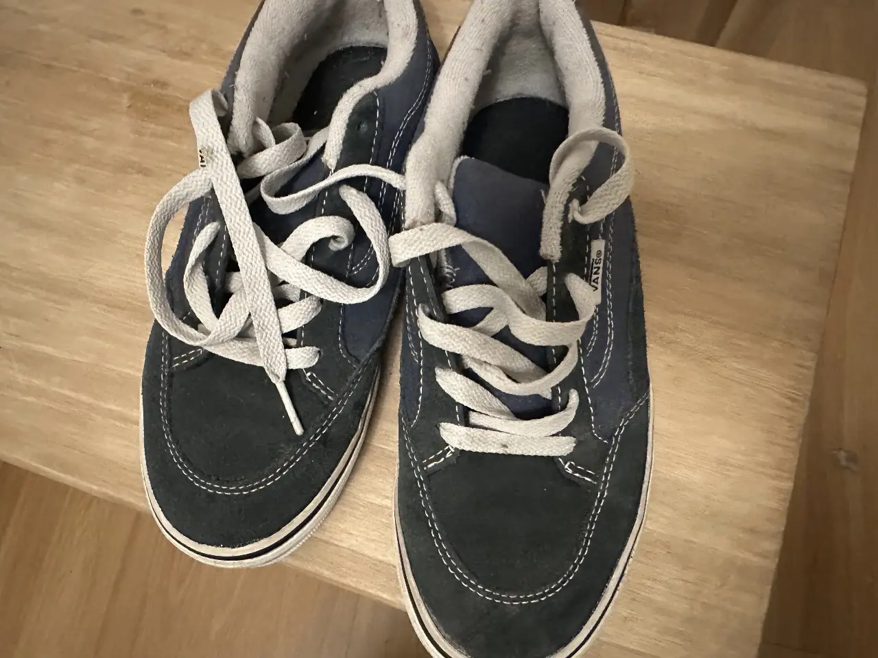 Zapatillas Vans azules y blancas para niños. Diseño clásico con cordones y suela de goma.