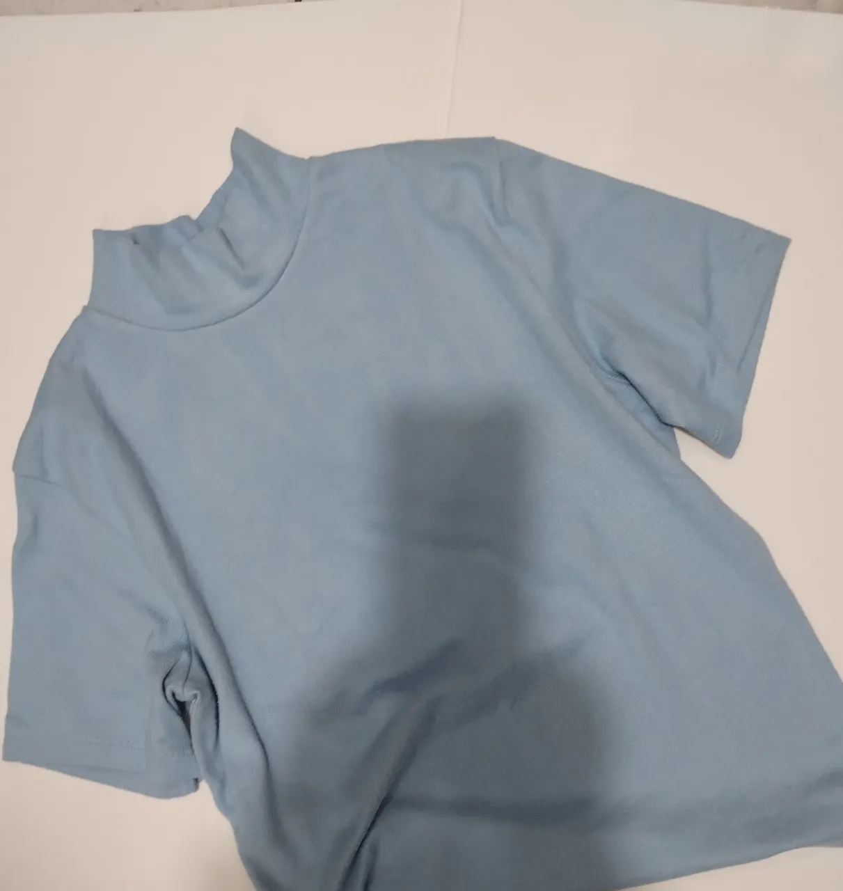 Remera de cuello alto para mujer, manga corta, ideal para un look casual y moderno. Confeccionada en un tejido suave y ligero, perfecta para combinar con jeans o faldas.