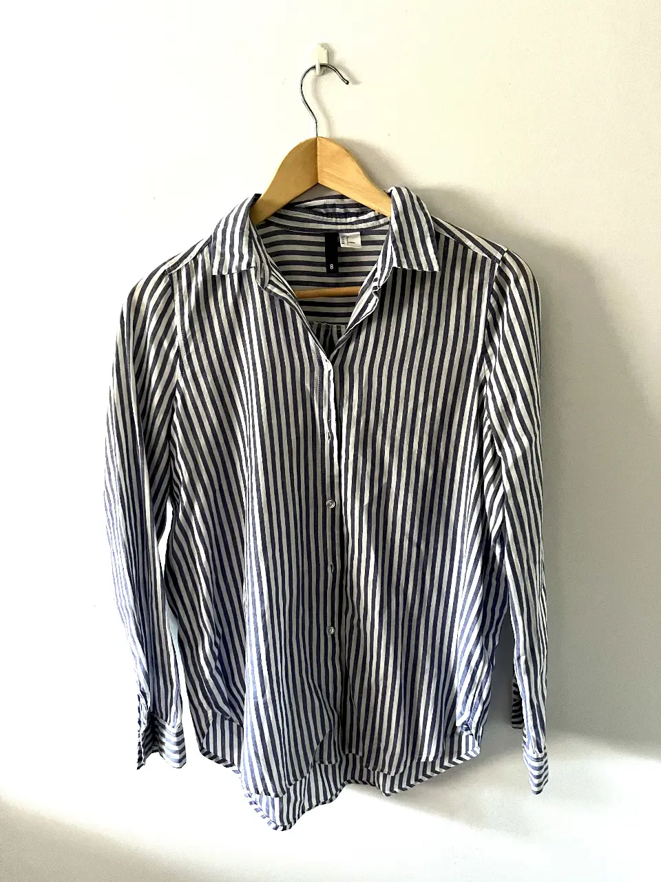 Camisa a rayas verticales en blanco y azul, ideal para un look casual y fresco. Confeccionada en un tejido ligero y cómodo, perfecta para combinar con jeans o pantalones de vestir.