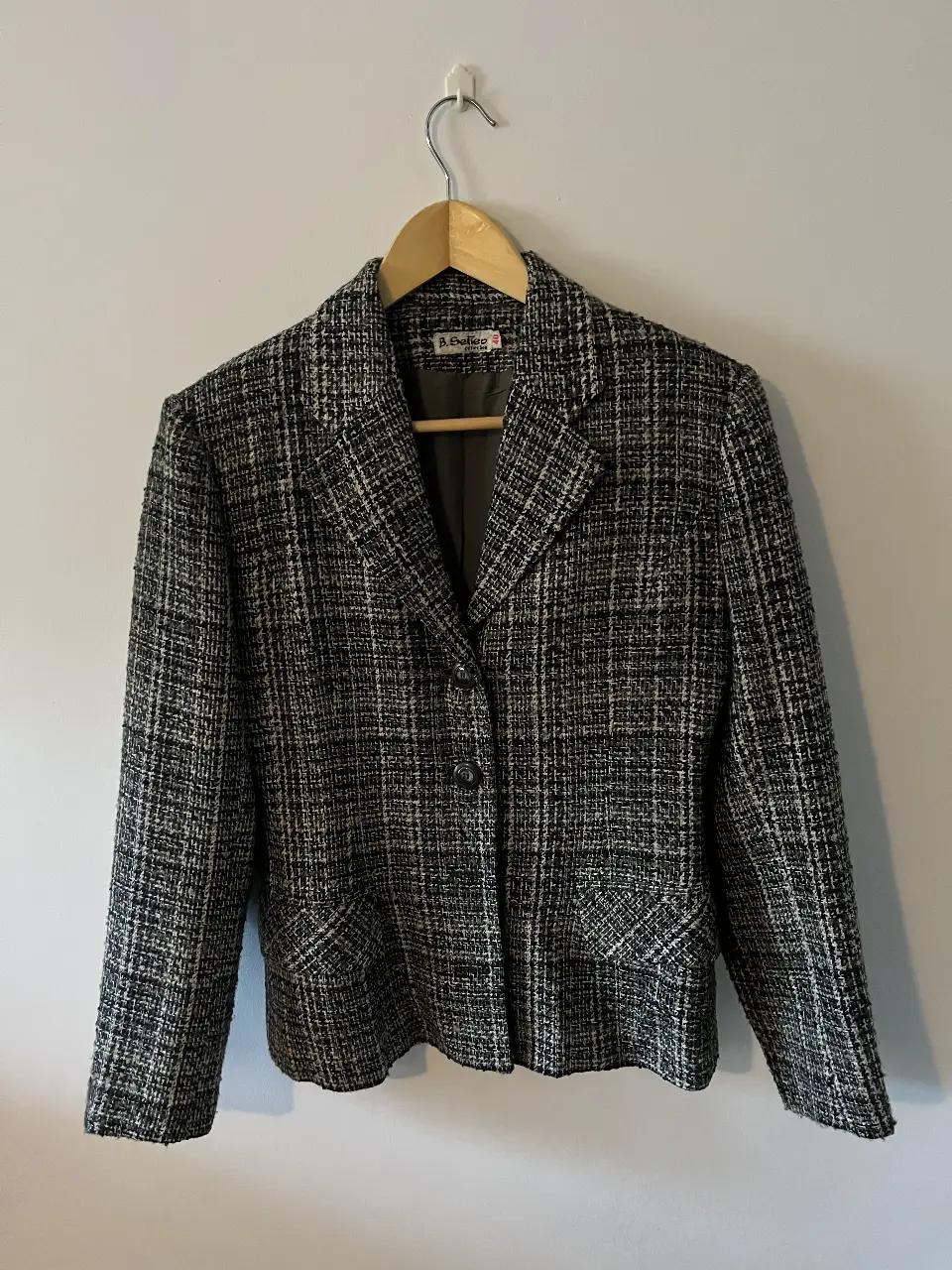 Blazer de tweed en tonos grises y negros, ideal para un look elegante y sofisticado. Perfecto para combinar con pantalones sastreros o jeans para un estilo más casual.