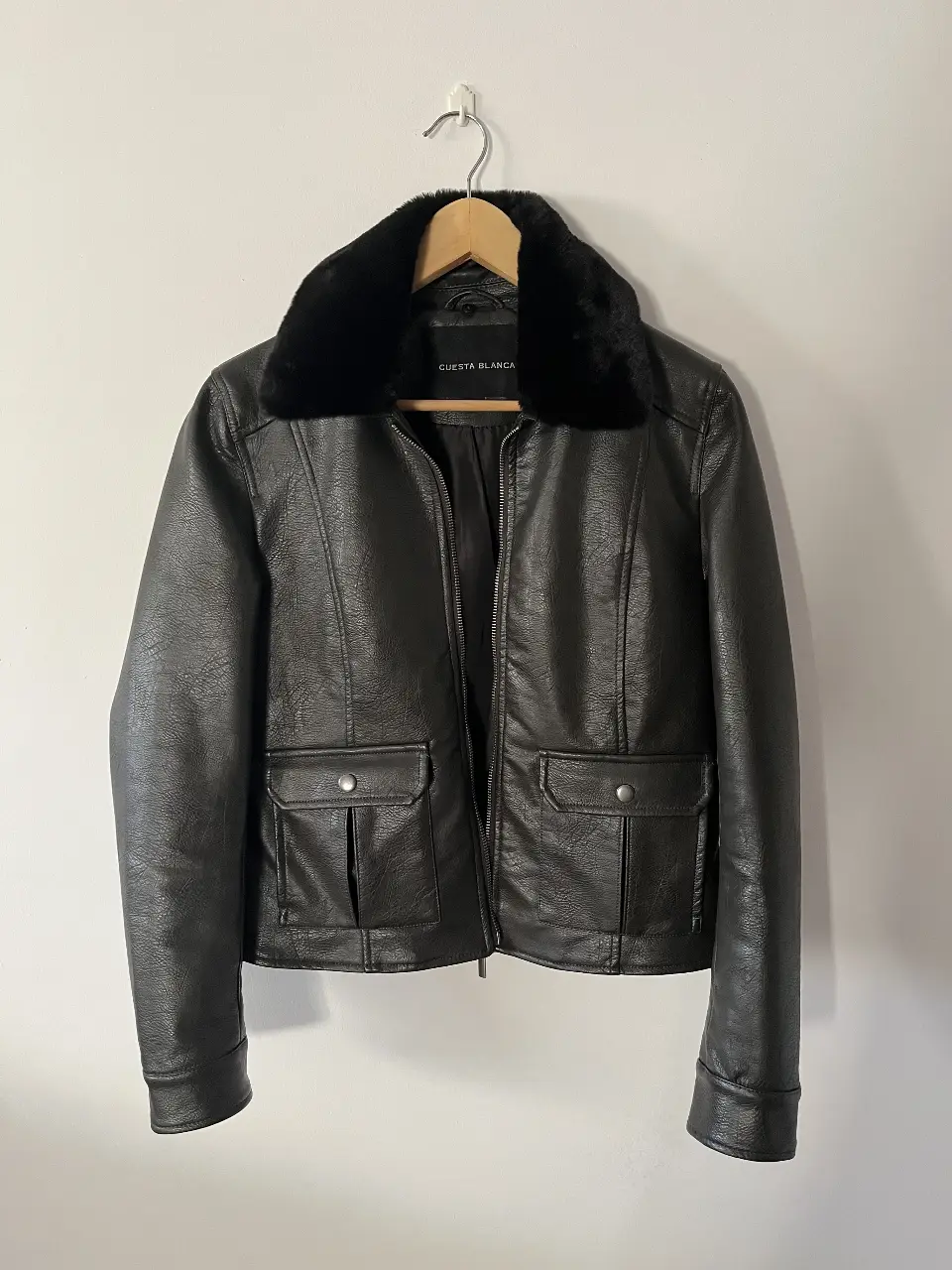Campera de cuero sintético negra con cuello de piel sintética. Posee dos bolsillos delanteros con solapa. Ideal para un look moderno y abrigado.
