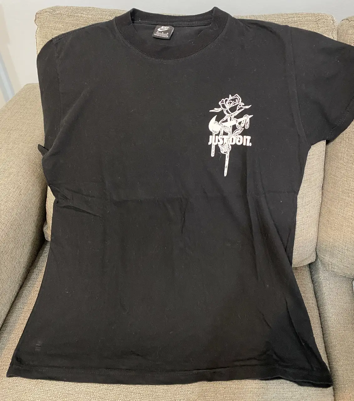 Remera negra de hombre con estampado blanco en el frente y la espalda. Diseño de Nike (no es original) con detalles de flores y el logo de la marca.
