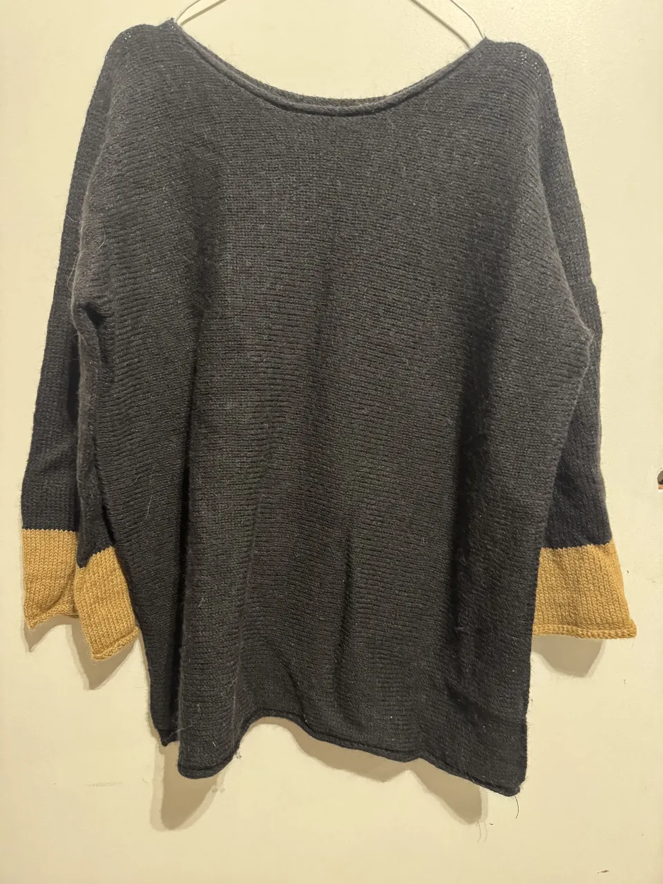 Sweater largo de color negro con mangas en color khaki. Ideal para un look casual y abrigado.