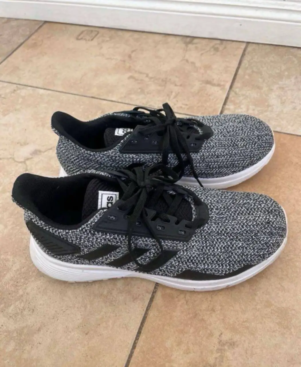 Zapatillas Adidas, color gris y negro, ideales para running y uso diario. 