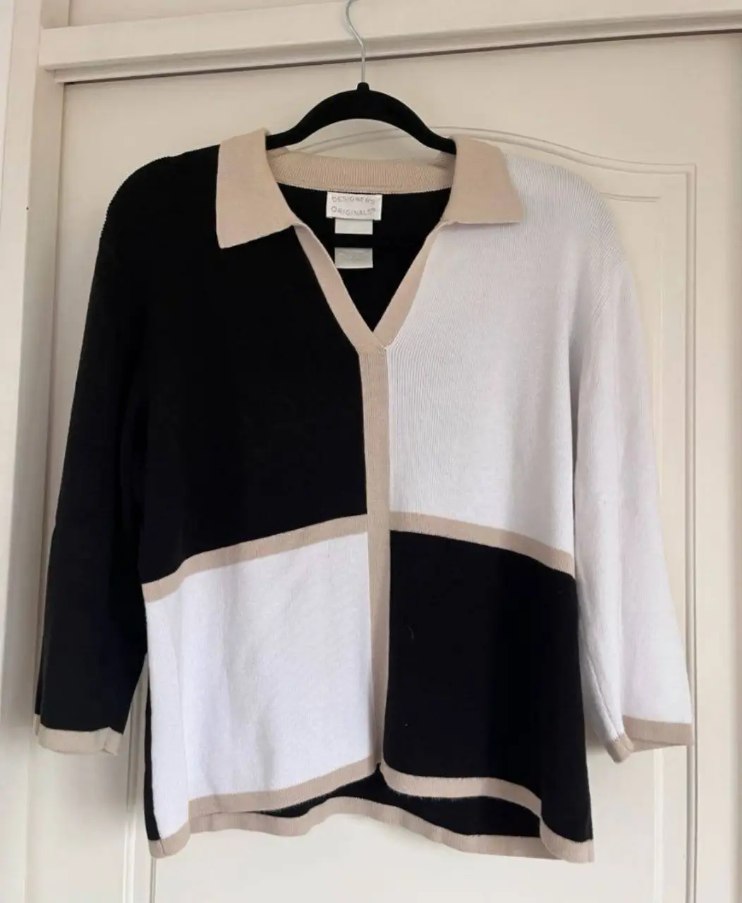Sweater de mujer con diseño geométrico en blanco y negro, con detalles en beige. Cuello en V y mangas 3/4. Ideal para un look casual y elegante. Medidas: Largo: 56cm, Ancho: 48cm