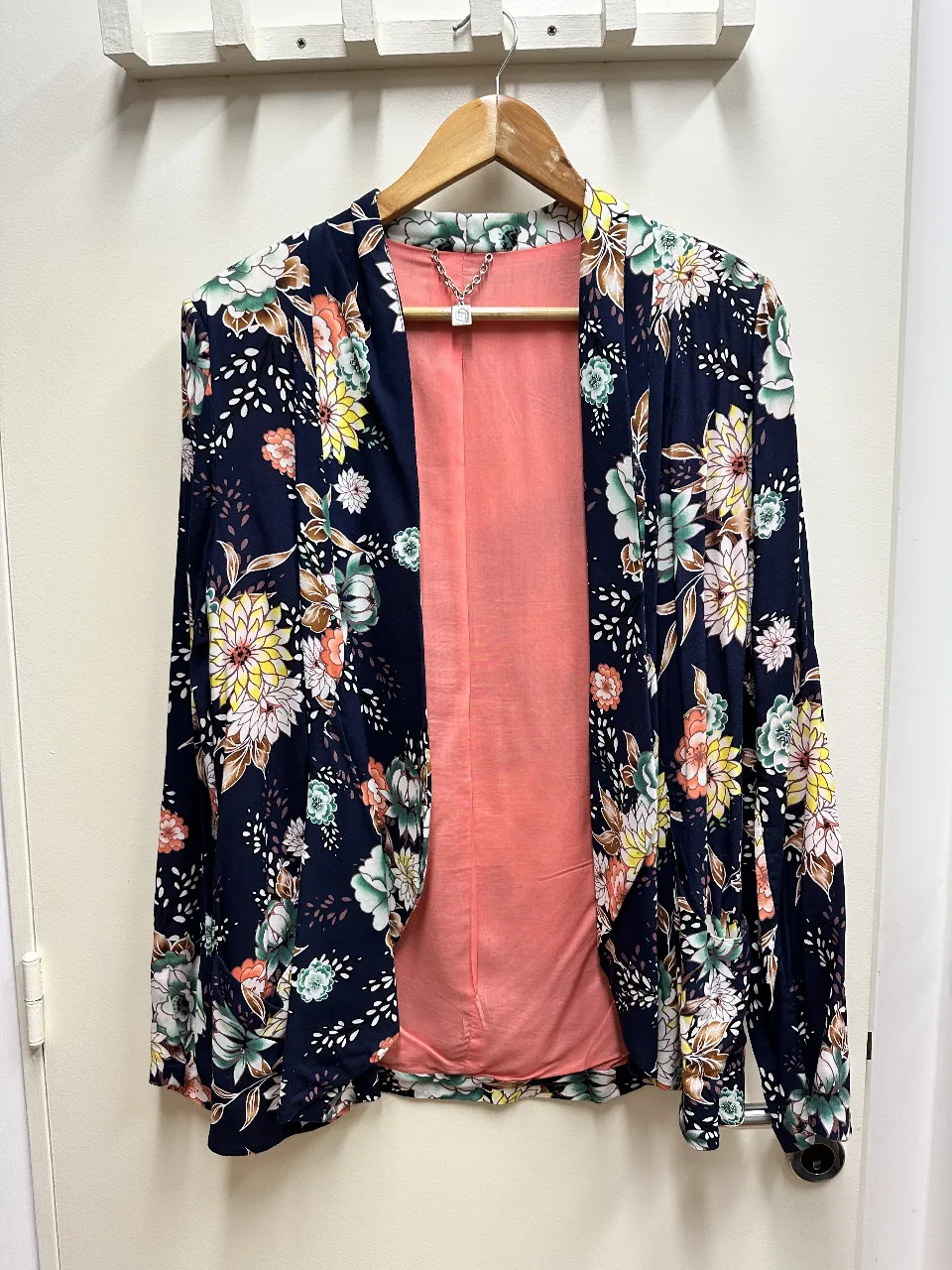 Elegante blazer de mujer con estampado floral en tonos azules, amarillos y rosas. Forro interior en color durazno. Ideal para un look sofisticado y primaveral.