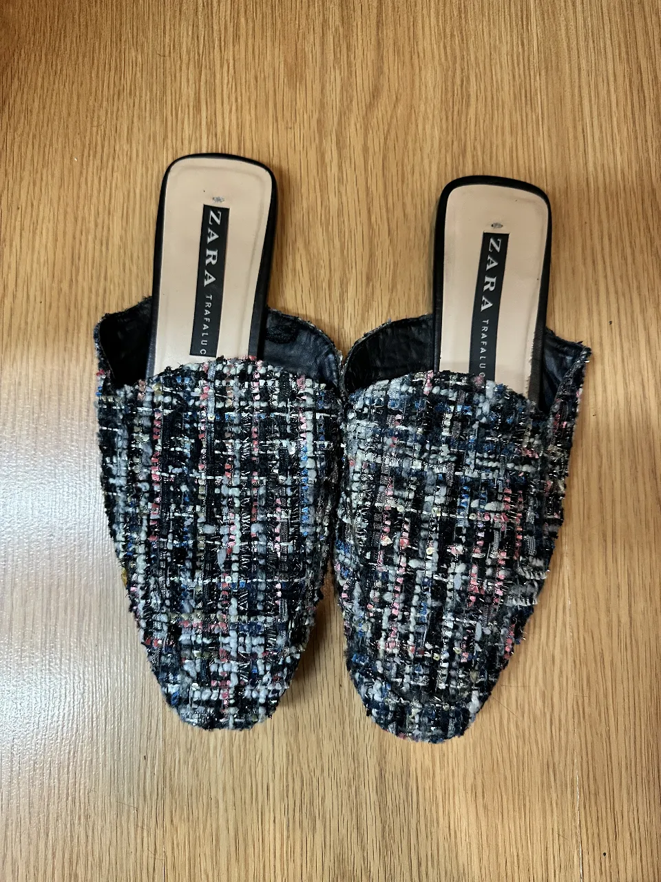 Mules de mujer de la marca Zara Trafaluc, con diseño de tweed en tonos oscuros y plantilla negra. Ideales para un look elegante y moderno.