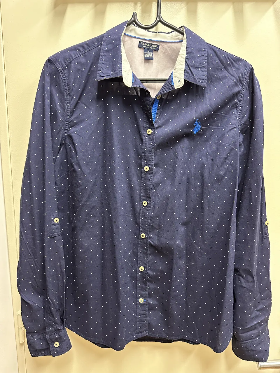 Camisa de hombre de la marca U.S. Polo Assn., de manga larga, con estampado de lunares blancos sobre fondo azul marino. Confeccionada en algodón, ideal para un look casual y moderno.