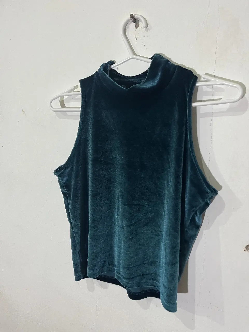 Top de terciopelo verde con cuello alto, ideal para un look elegante y sofisticado. Perfecto para combinar con pantalones de vestir o polleras.