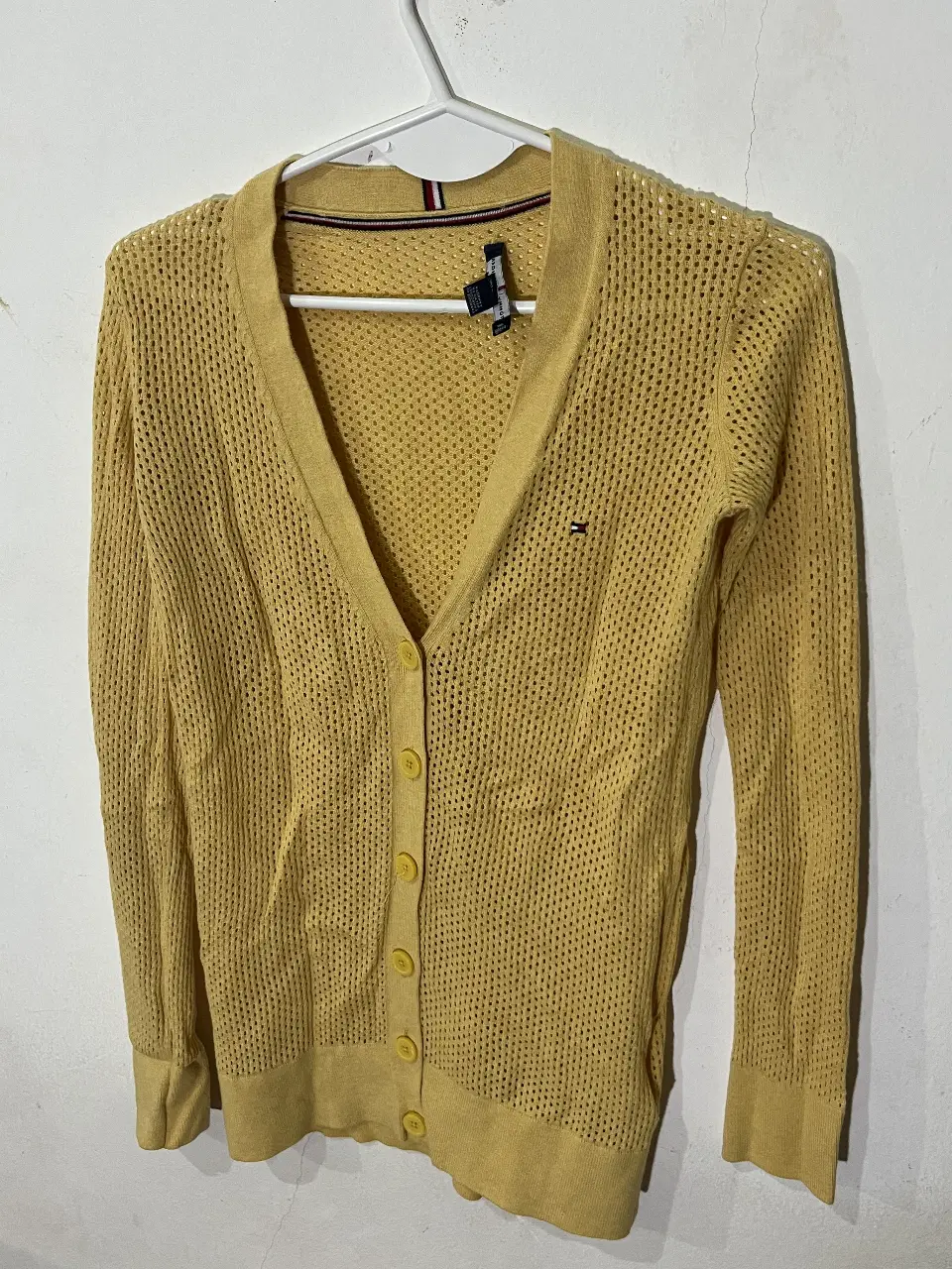 Cardigan Tommy Hilfiger amarillo, tejido calado, con botones y logo bordado. Ideal para un look casual y fresco.