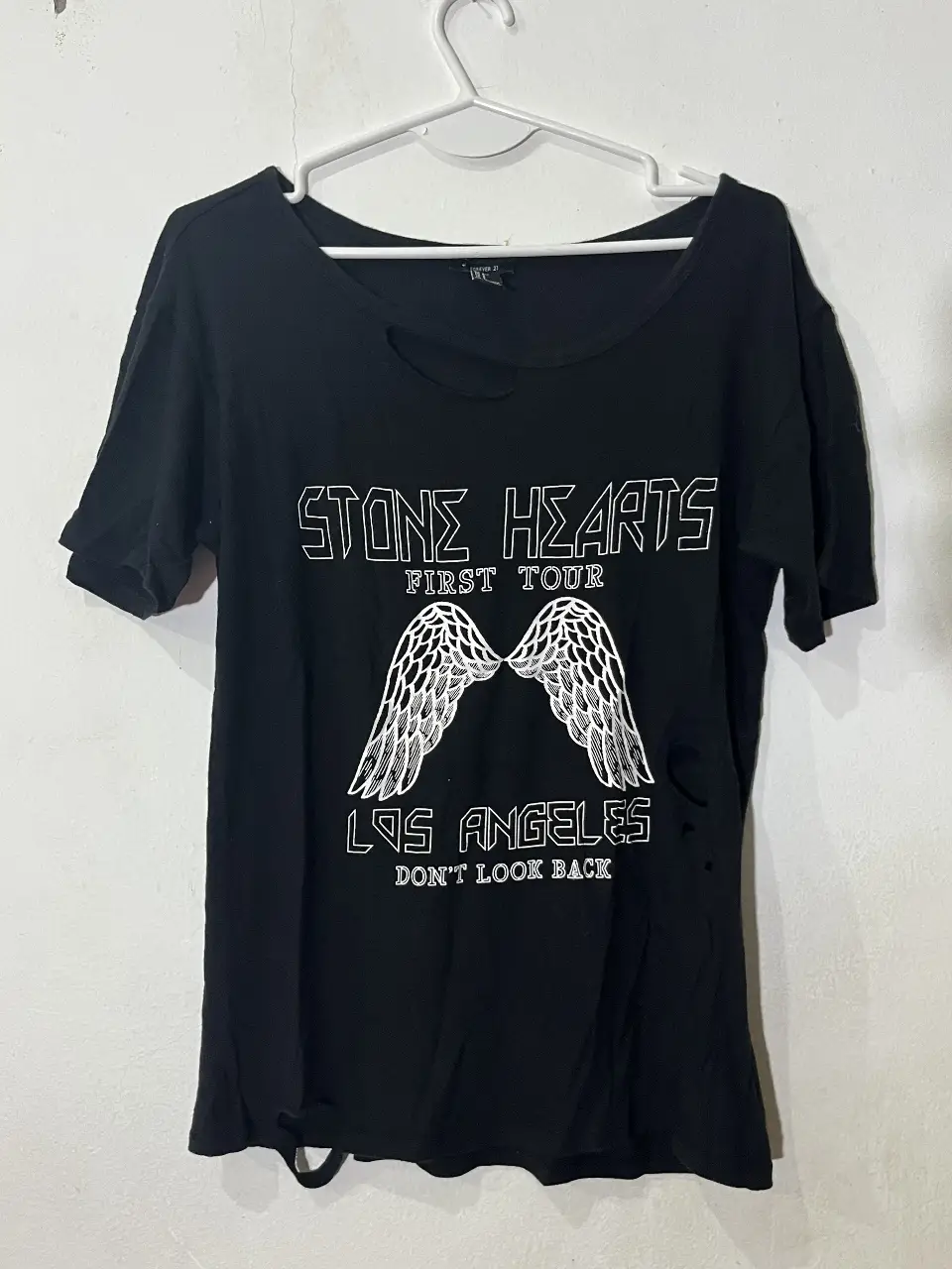 Remera negra de Forever 21 con estampado super canchero. Corte holgado, con detalles de roturas y cuello redondo.