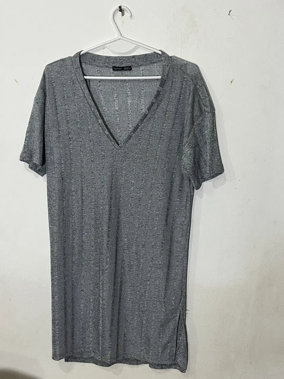 Remera larga gris de Zara, con cuello en V y mangas cortas. Ideal para un look casual y cómodo. Talle  S/M
