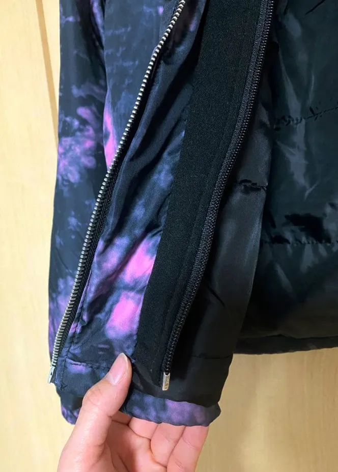 Campera con capucha y estampa tie-dye en negro y fucsia. Cierre al frente y bolsillos laterales.