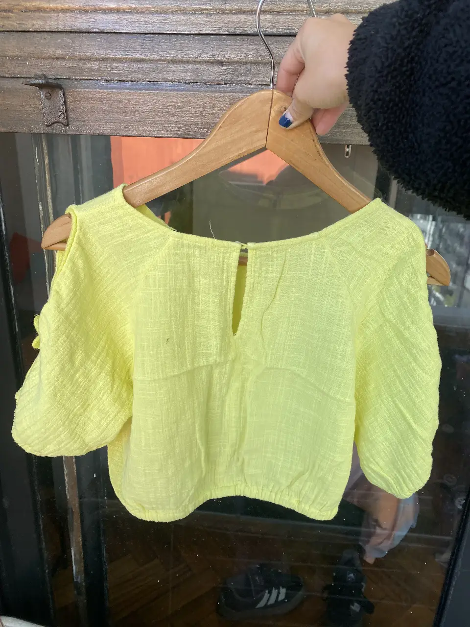 Blusa amarilla de tela liviana, con mangas cortas y detalle de volados. Ideal para un look fresco y casual.