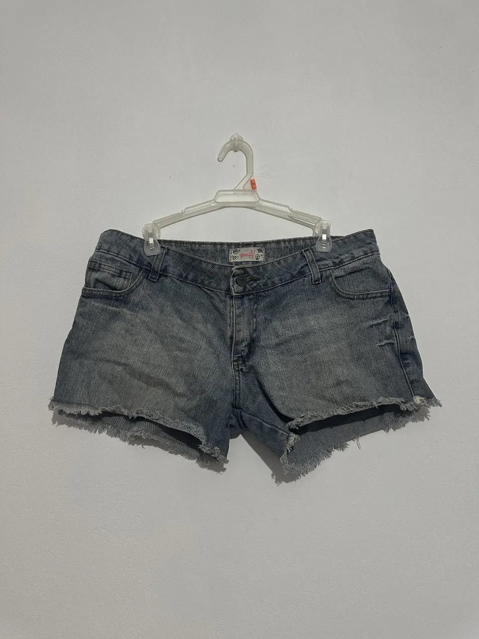 Short de jean de mujer, tiro medio, flecos en el borde. Ideal para un look casual y moderno.