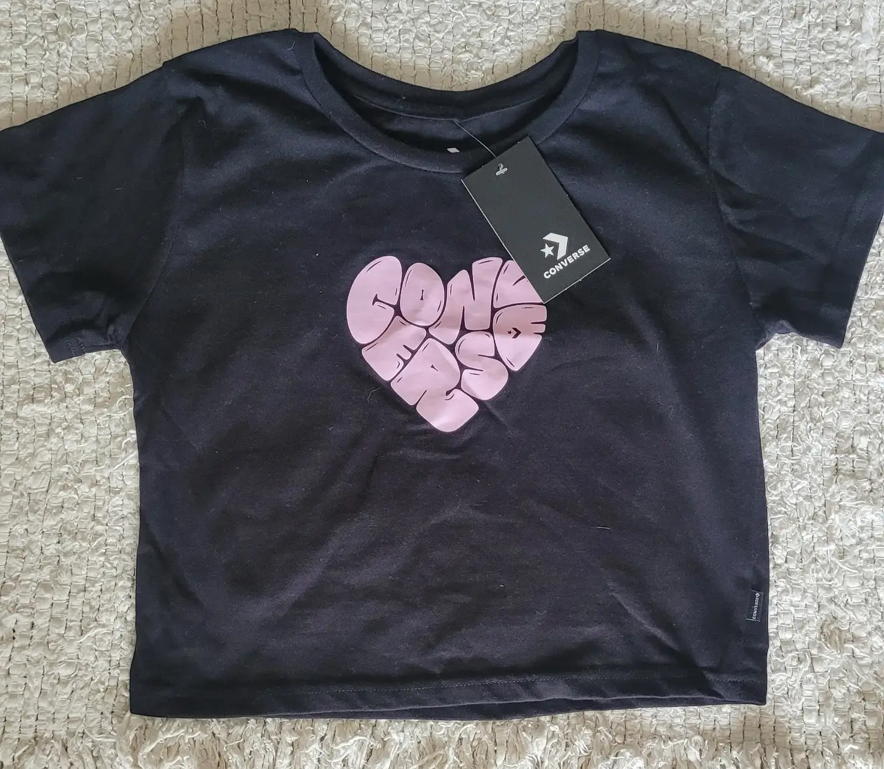 Remera Converse negra de mujer, con estampa de corazón con la palabra "CONVERSE" en rosa. Talle M, hecha en Argentina.