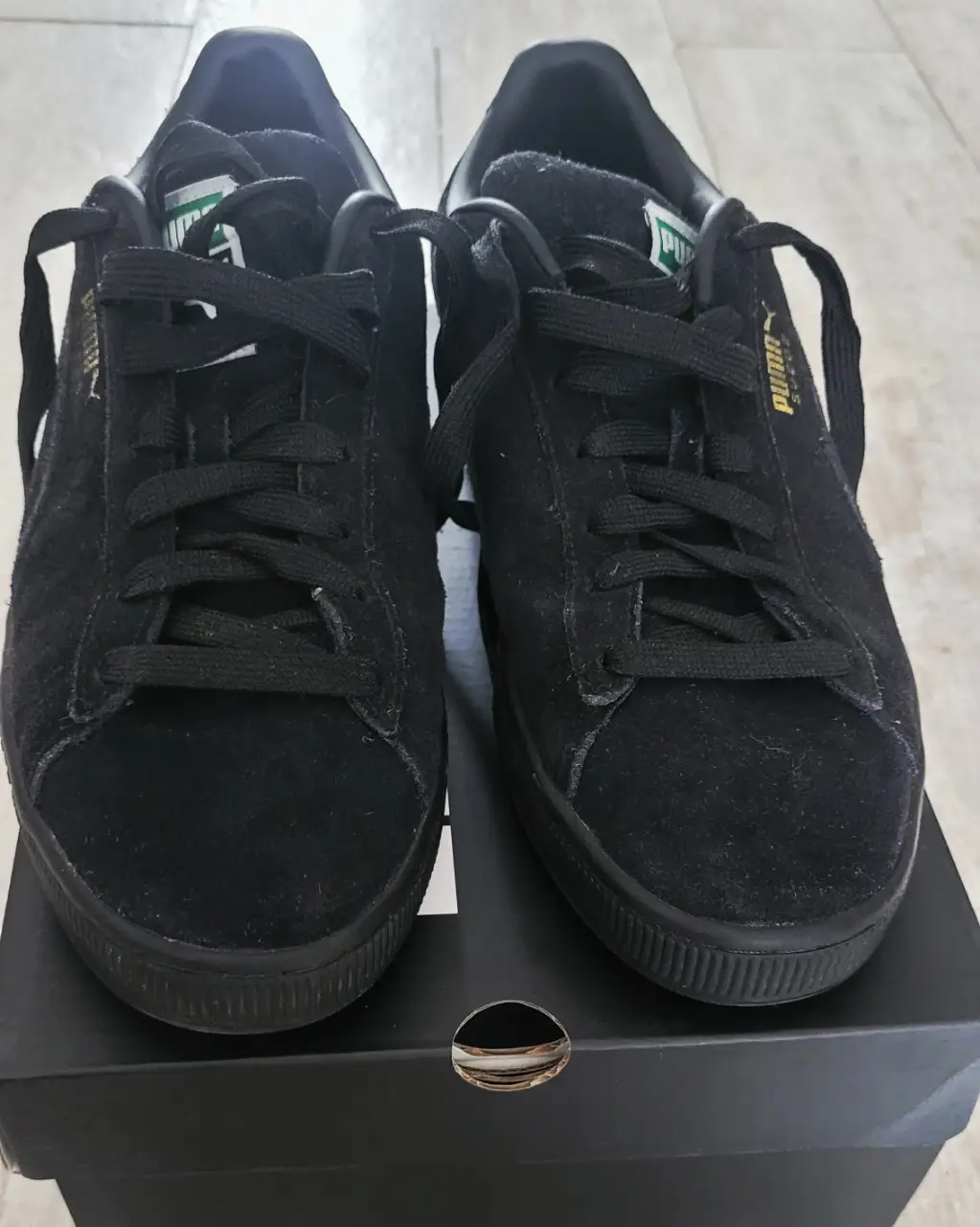 Zapatillas Puma Suede negras, ideales para un look casual y urbano. Confeccionadas en gamuza, estas zapatillas ofrecen comodidad y estilo. El logo dorado de Puma le da un toque distintivo. Perfectas para combinar con cualquier outfit. No tiene detalles, solo 2 usos, la plantilla mide 27 cm