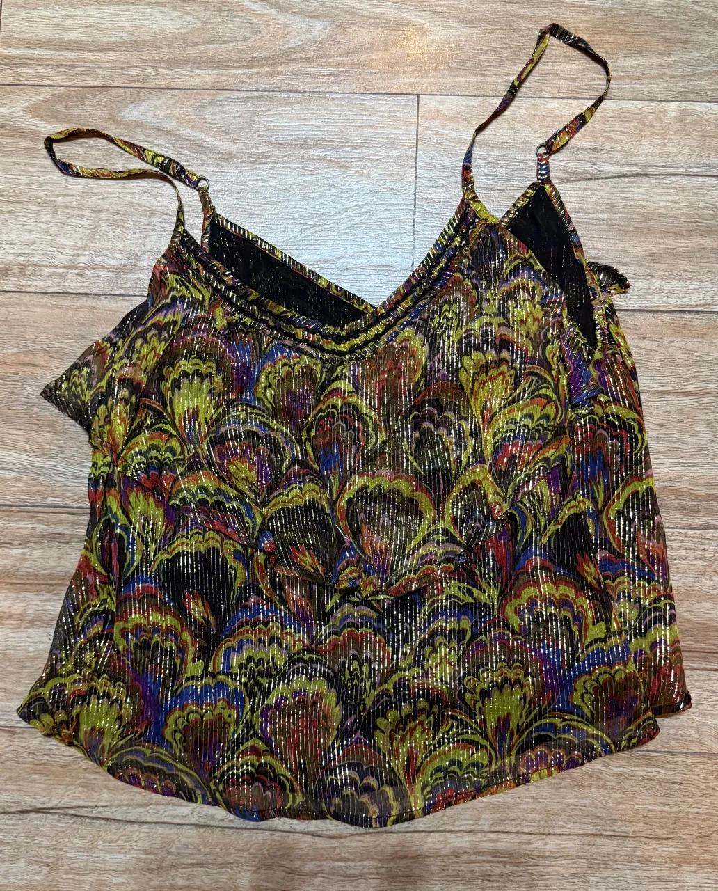 Musculosa estampada con breteles finos y escote en V. Posee detalles de brillos metálicos en toda la prenda.