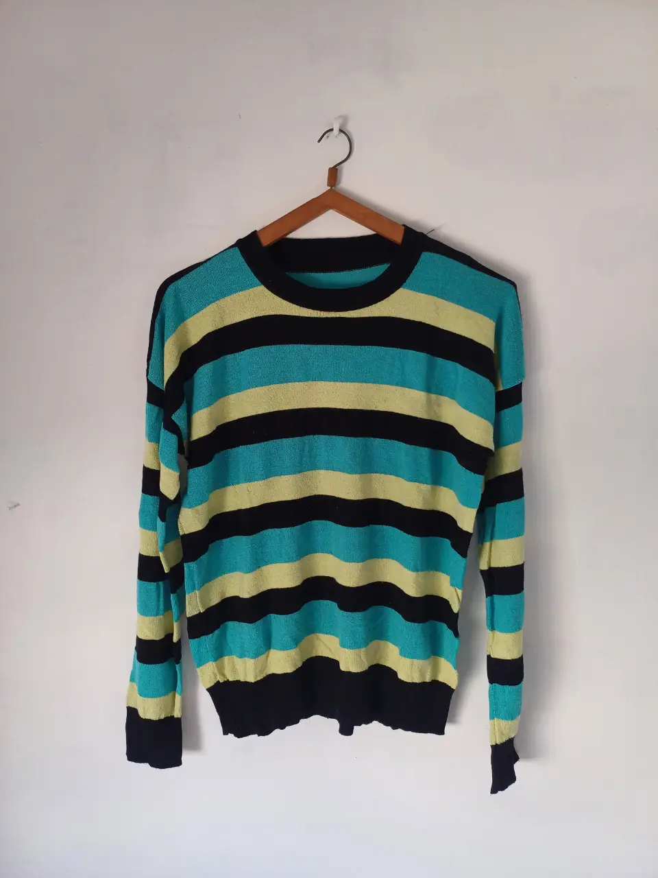 Sweater a rayas horizontales en color negro, azul y amarillo. Corte oversize. De hilo.