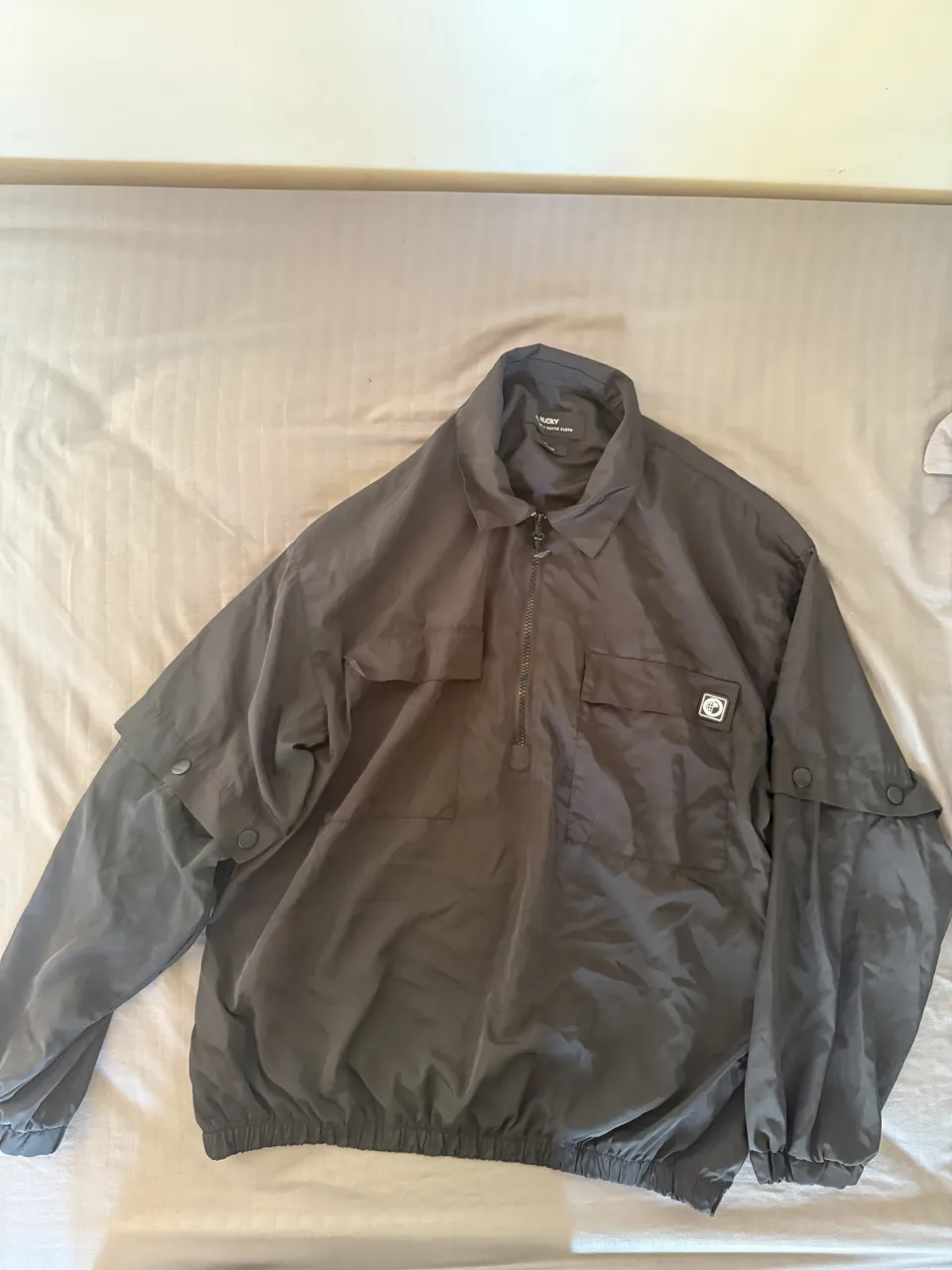 Campera rompevientos negra, ideal para un look urbano y moderno. Posee bolsillos frontales y detalles en las mangas. se le pueden sacar las mangas.