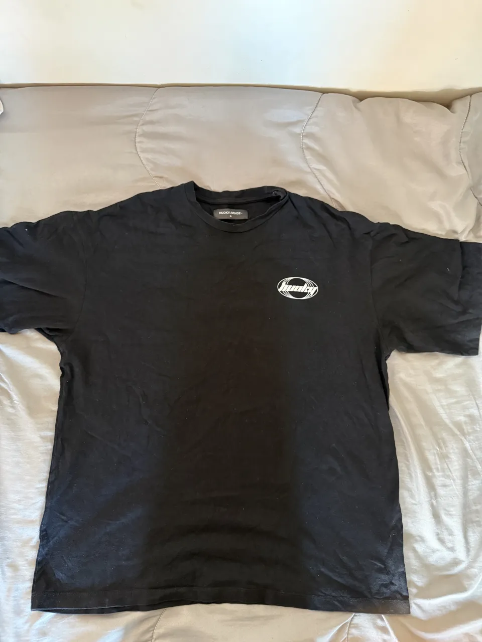 Remera negra oversize con estampa de "smiley" de alambre de púas en la espalda y logo en el frente. Ideal para un look urbano y canchero.