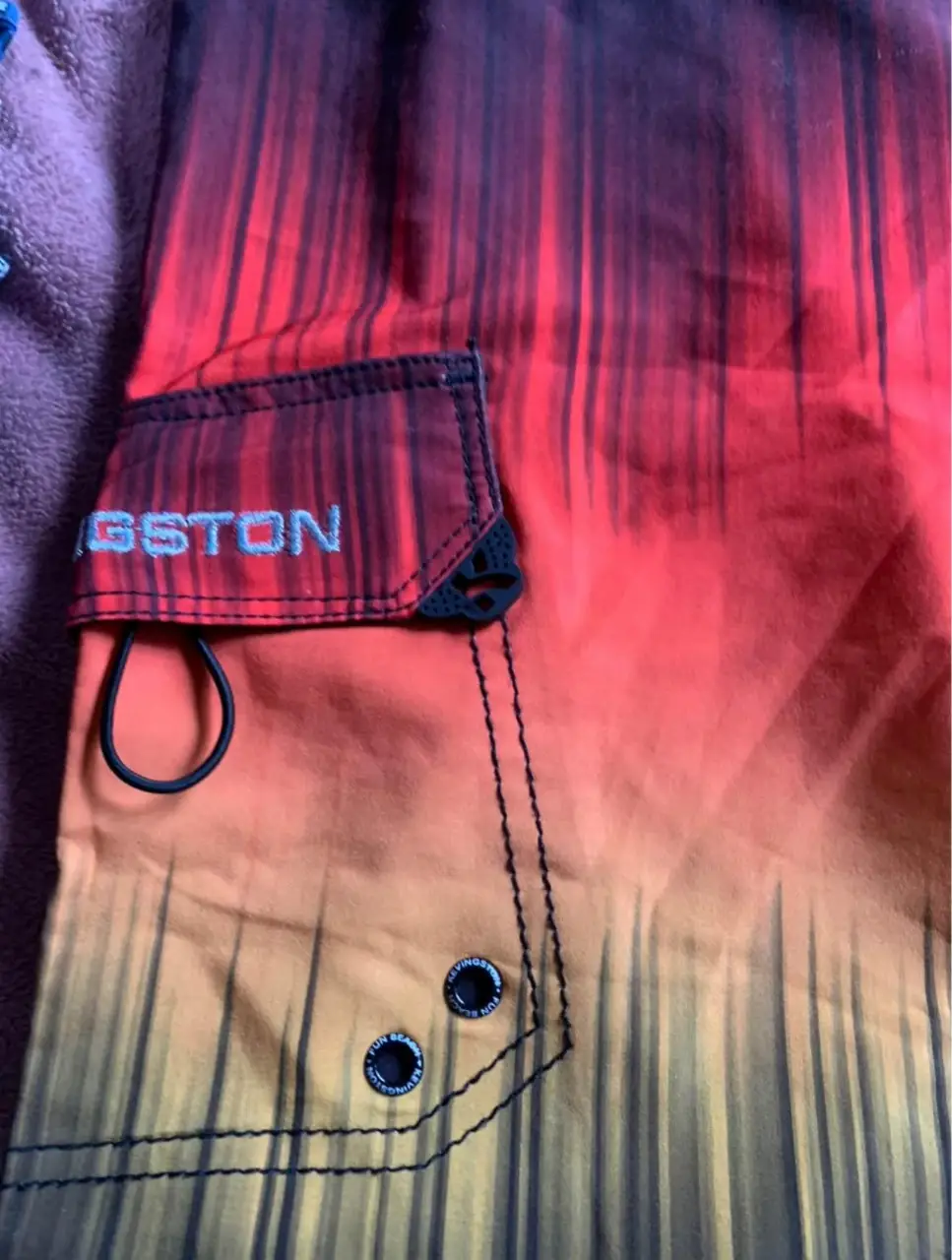 Short de baño KEVINGSTON con diseño degradado en tonos naranja y amarillo. Cuenta con bolsillo lateral y cordón ajustable en la cintura. Ideal para la playa o actividades acuáticas.