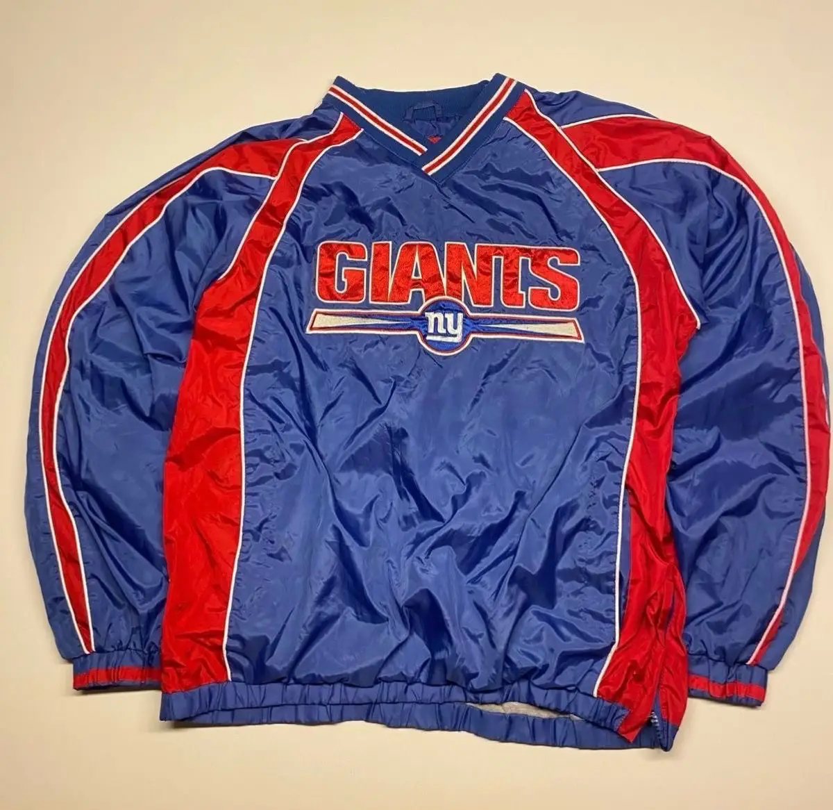 Campera rompevientos de los New York Giants, con el logo del equipo en el frente. Abrigada por dentro. Ideal para usar en días frescos o para actividades deportivas.