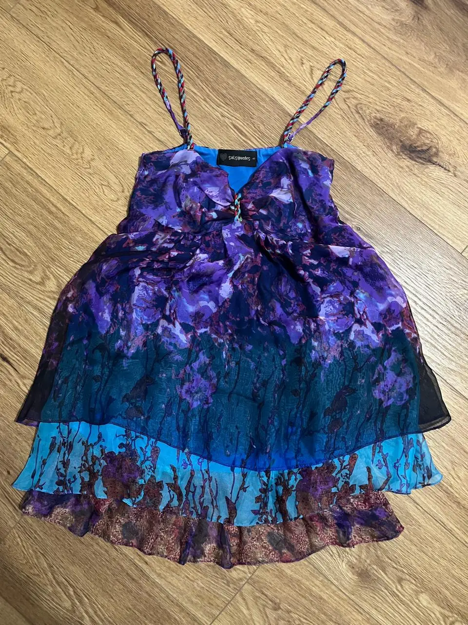 Vestido mini de mujer, con tirantes finos y diseño floral en tonos violetas y azules. Ideal para un look fresco y femenino.