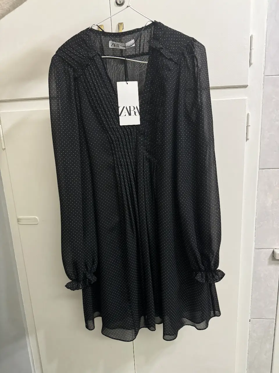 Vestido mini de Zara, negro con lunares blancos. Talle M, con mangas largas y puños con volados. Ideal para una salida o fiesta.