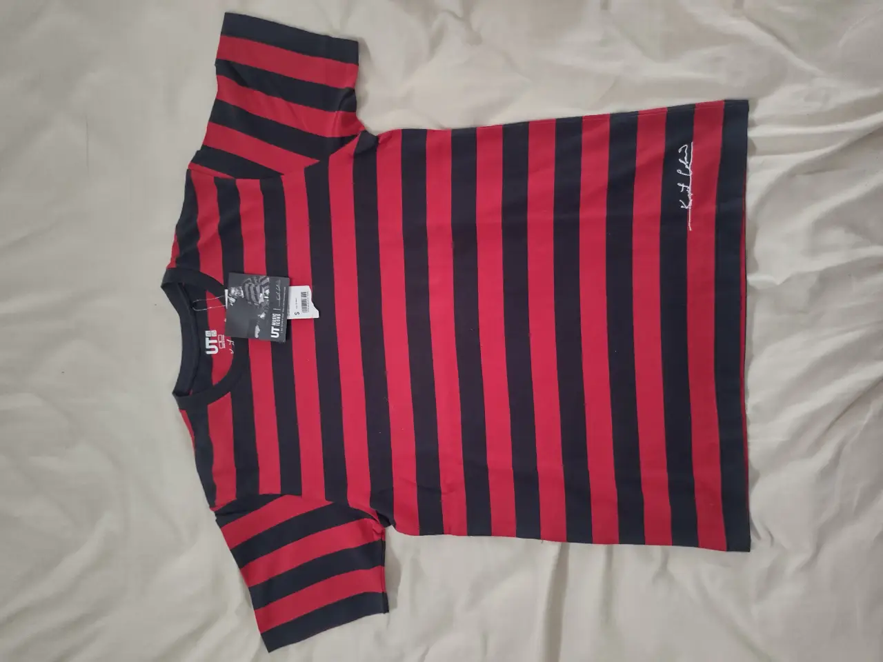 Remera de hombre a rayas rojas y negras, con estampado de Kurt Cobain y la marca Uniqlo nuevo, sin uso. Talle S. Ideal para un look rocker y casual.