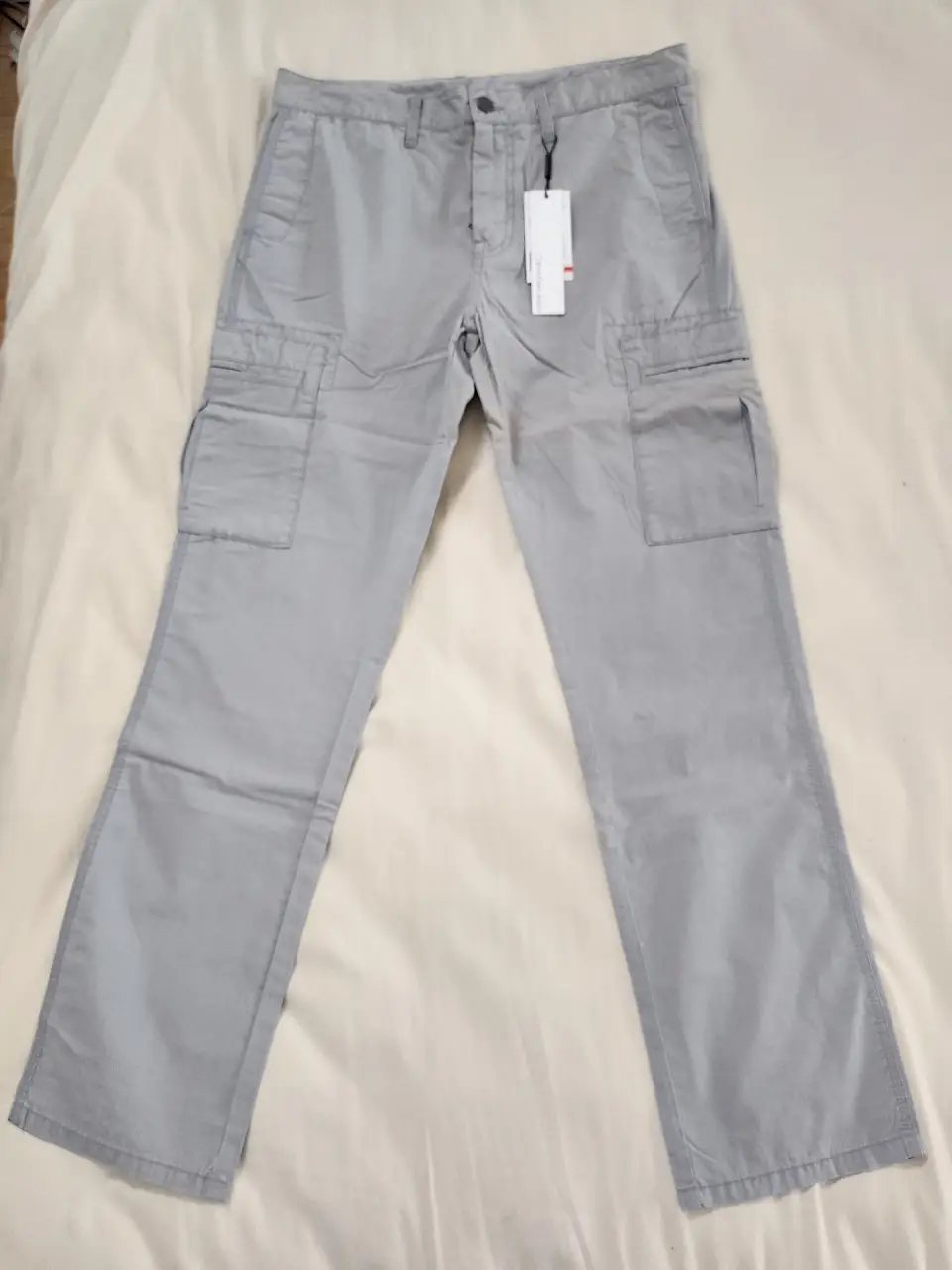 Pantalón Calvin Klein cargo gris claro para hombre, con múltiples bolsillos y corte recto. Nuevo, sin uso.  Ideal para un look casual y funcional.