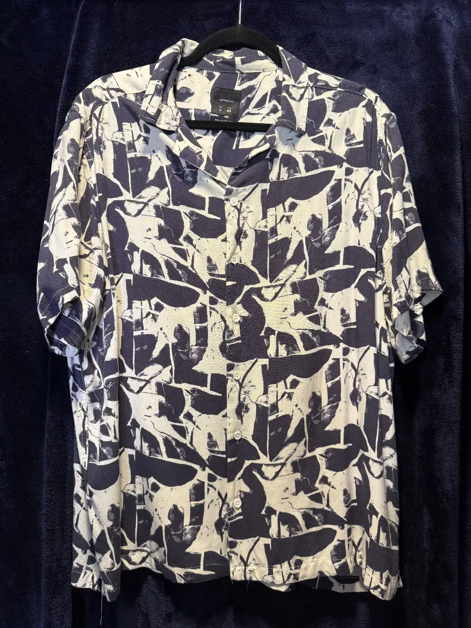 Camisa estampada de hombre, con un diseño abstracto en blanco y azul. Corte relajado, ideal para un look casual y moderno. Perfecta para usar en salidas o eventos informales.