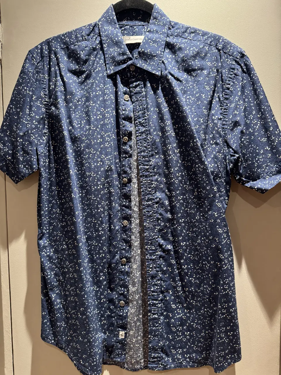 Camisa de hombre con estampado floral en tonos azules y blancos. Corte clásico, manga corta y botones. Ideal para un look casual y fresco.