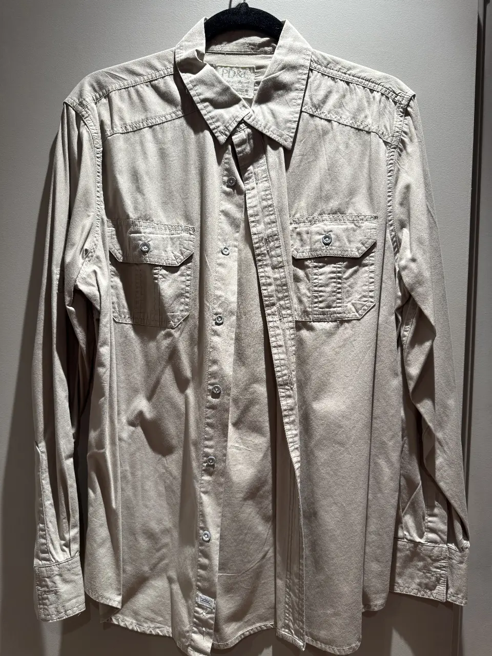 Camisa de hombre color crudo, con dos bolsillos delanteros y botones. Ideal para un look casual y cómodo.