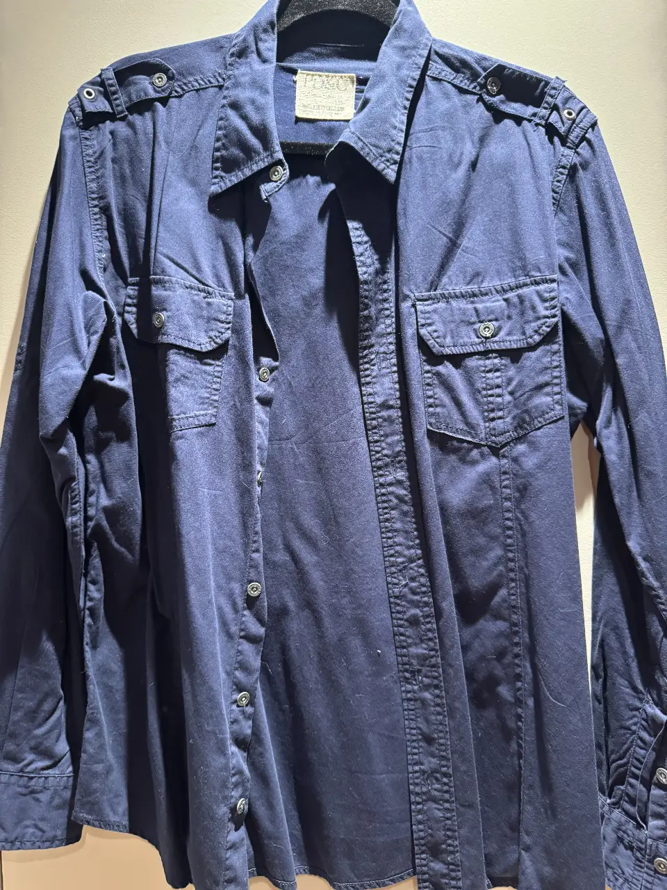 Camisa de hombre azul marino con dos bolsillos delanteros y detalles en los hombros. Ideal para un look casual y versátil.