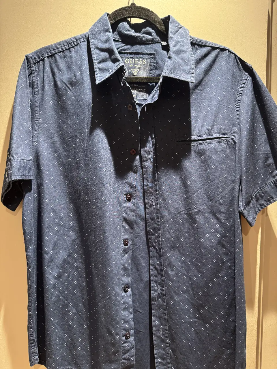 Camisa de hombre Guess, manga corta, azul con estampado sutil. Ideal para un look casual y moderno.