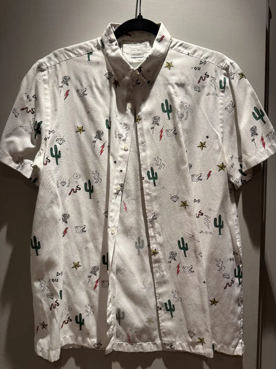 Camisa de hombre de manga corta con estampado de cactus, estrellas y otros diseños. Corte regular fit. Ideal para un look casual y moderno.