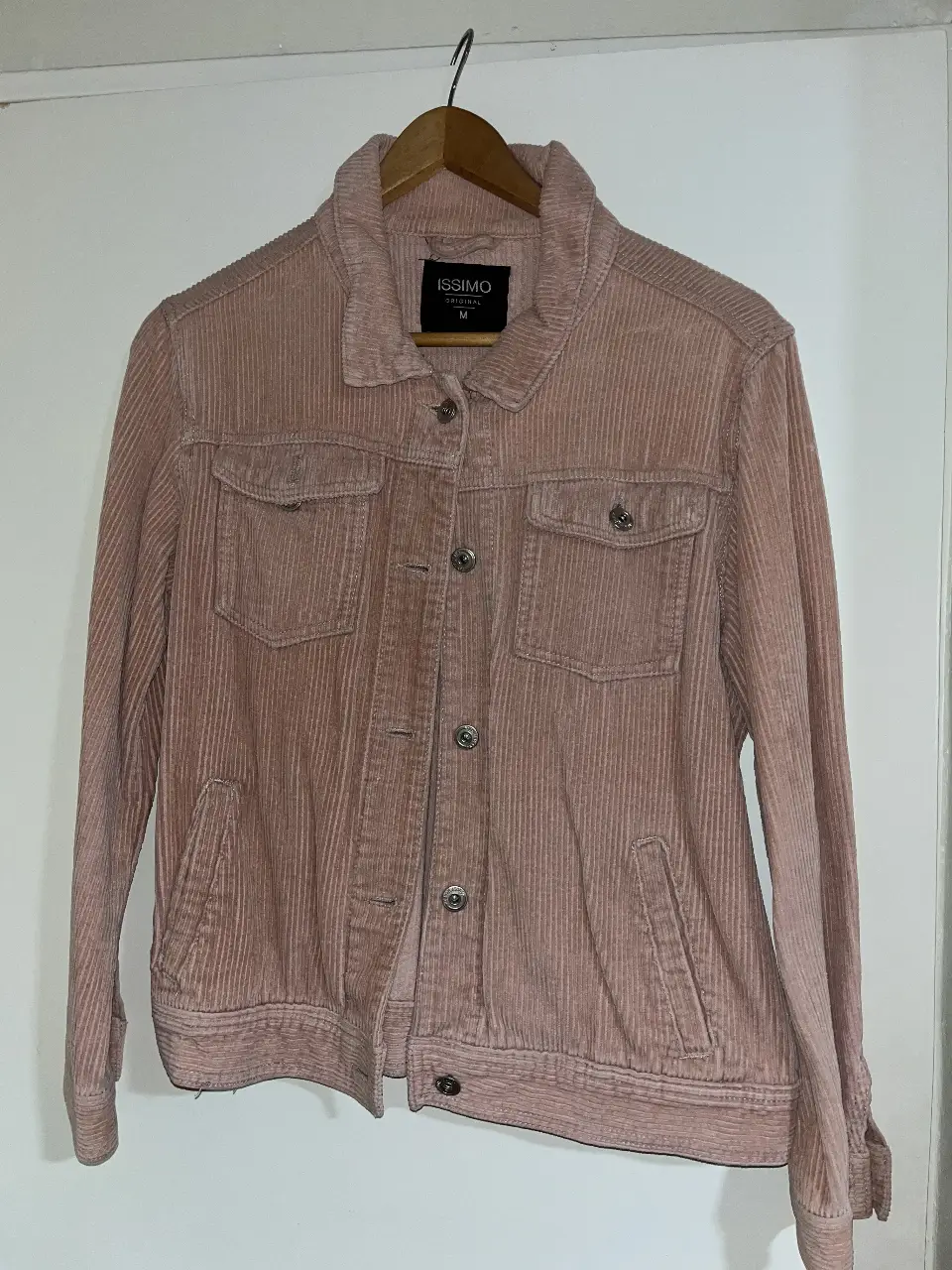 Campera de corderoy rosa, estilo bomber, con bolsillos delanteros y cierre con botones. Ideal para un look casual y canchero.