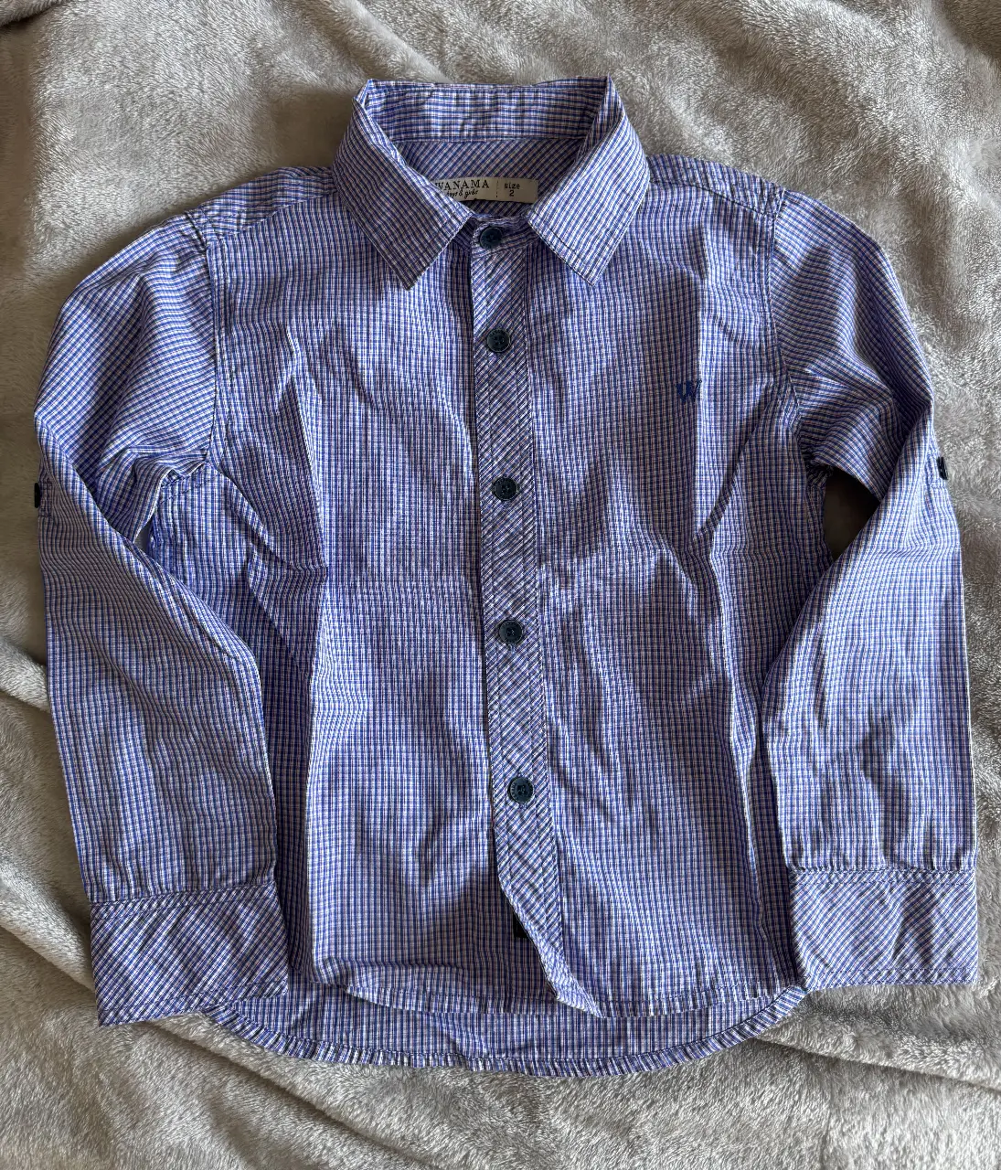 Camisa Wanama Kids talle 2, a cuadros azul blanco y rojo para niño, manga larga, con botones y cuello clásico. Ideal para un look casual y cómodo.