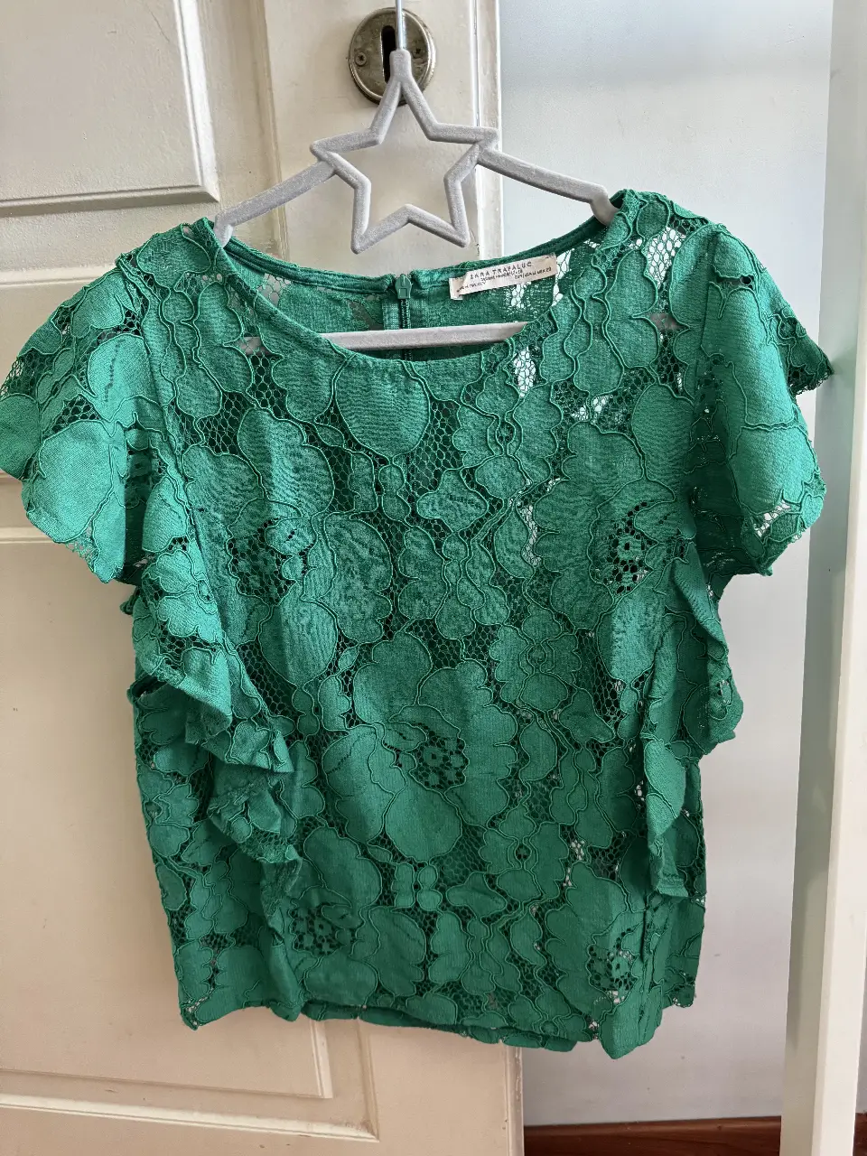 Blusa de encaje verde con detalles florales y volados en las mangas. Ideal para un look elegante y fresco. Zara