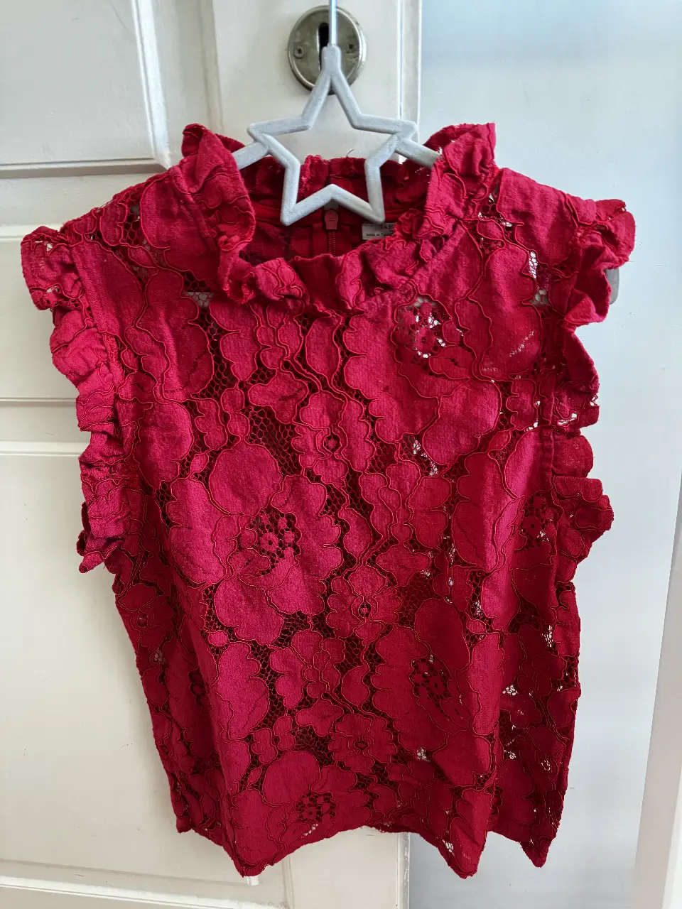 Blusa de encaje roja con cuello alto y volados en mangas y cuello. Ideal para un look elegante y femenino. Zara. 