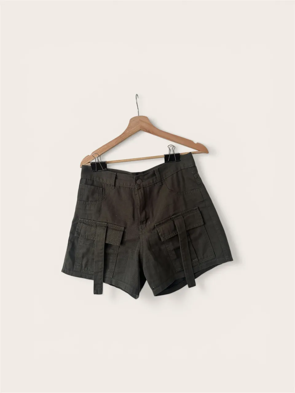 Shorts cargo de gabardina color verde militar. Tienen bolsillos grandes con solapa y tiras decorativas. Tiro alto y corte moderno, ideales para un look urbano y canchero.