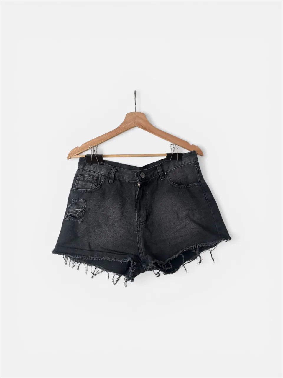 Shorts de jean negros con roturas y detalles desflecados en los bordes. Un clásico para el verano, ideales para un look casual y descontracturado.